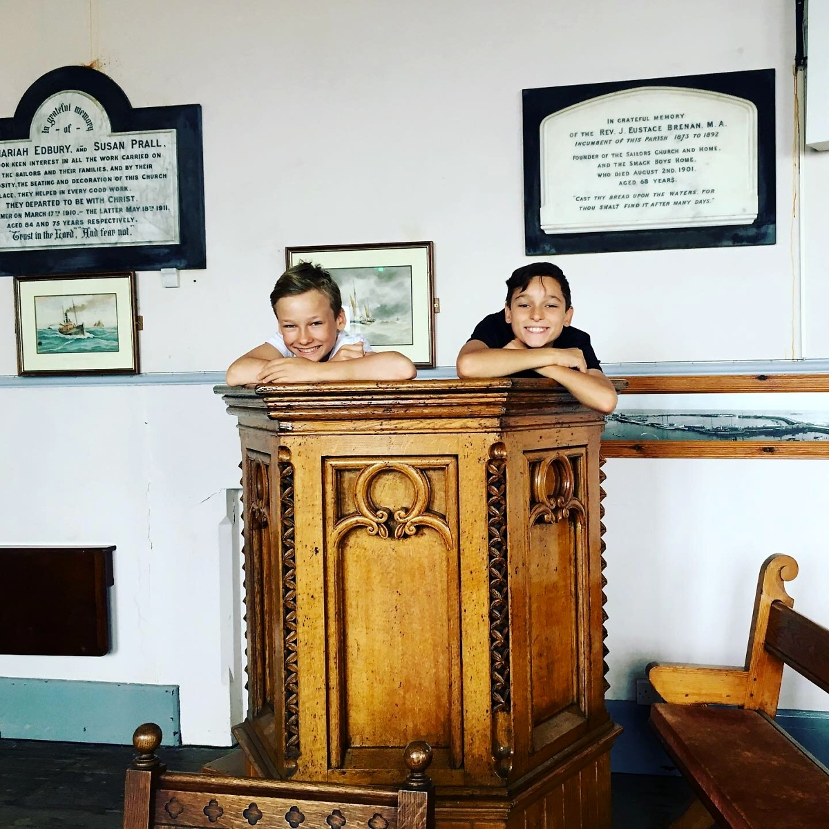 Two of the voice actors in Smack Boys, 10-year-old boys, stand in the pulpit in the smack boys church, smiling at the camera.