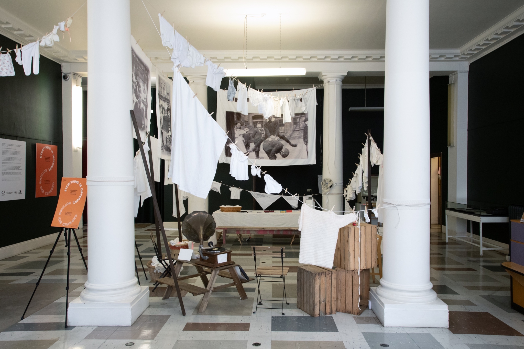 When We Were Young installed in Tower Hamlets Family History Library & Archives in Bethnal Green. The installation features lines of laundry hung across the four pillars in the centre of the room.
