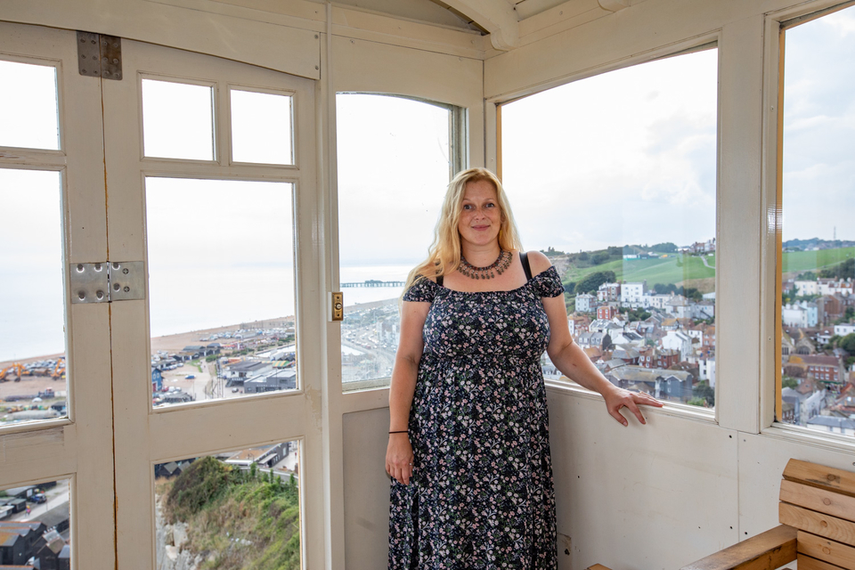 The East Hill lift, from the top. Emily is standing in the centre of the lift with the view of Hastings behind her.