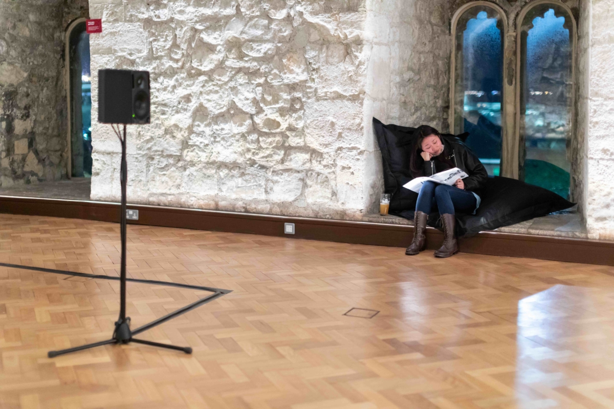A young woman sits in God's House Tower, listening to Emily Peasgood's 'When I Grow Up I Want To Be A Ship' recording. A speaker is placed in the centre of the gallery space.